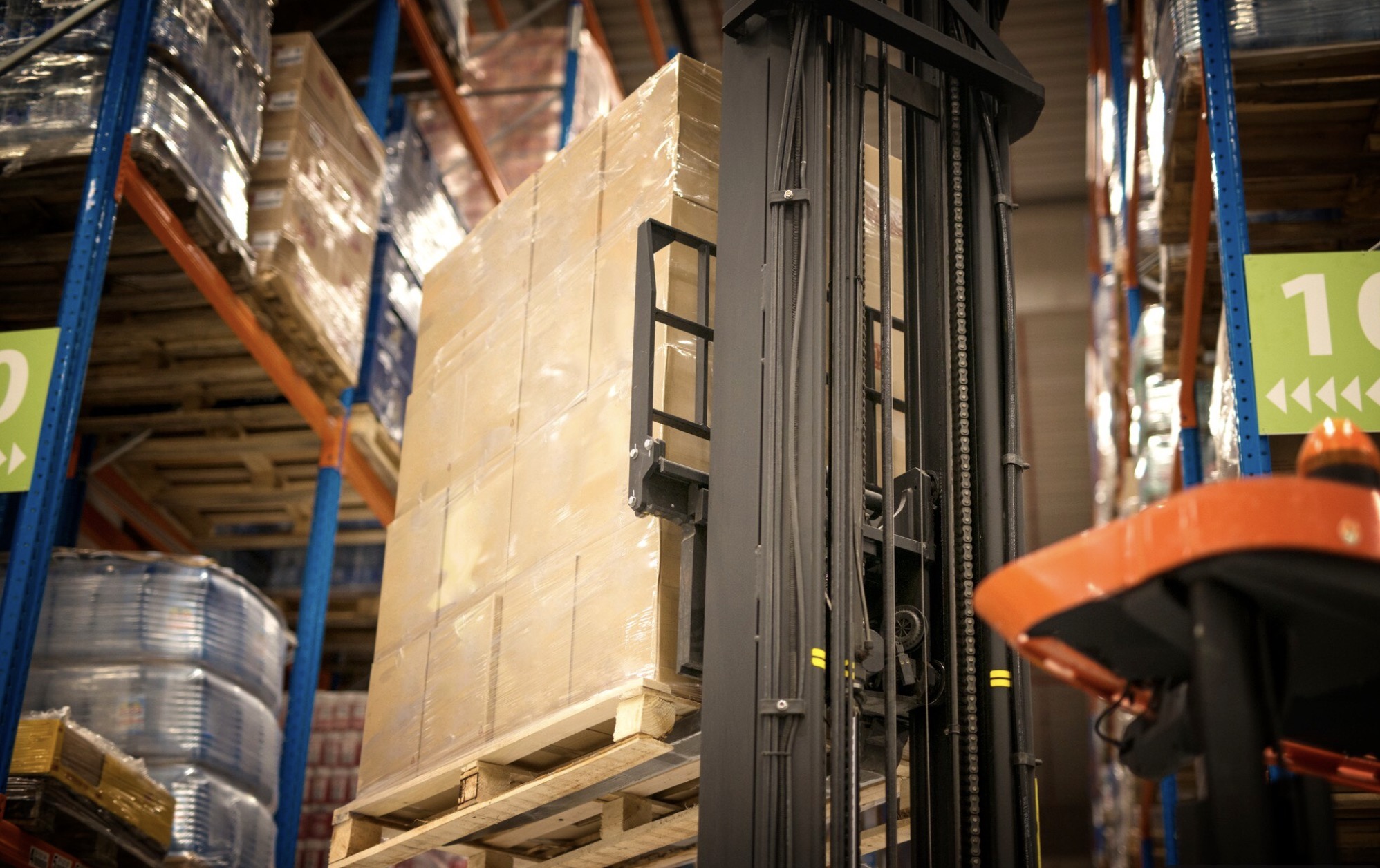 Frozen food distribution photo of boxes on forklift with warehouse shelves and frozen items behind